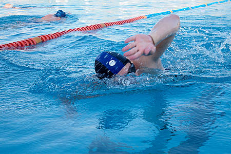 Schwimmer krault im Schwimmbecken