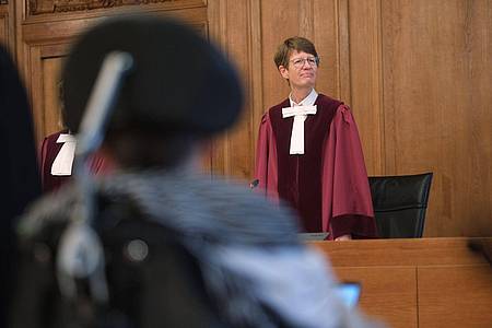 Renate Philipp, Versitzende Richterin am Bundesverwaltungsgericht, steht während der Verhandlung im Gerichtssaal in Leipzig. Im Vordergrund sitzt einer Kläger im Rollstuhl.