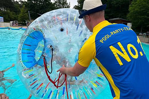 Riesiger Wasserball bei Poolparty im Freibad