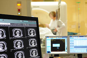 Röntgenufnahmegerät im Hintergrund und Monitore, die eine Aufnahme zeigen